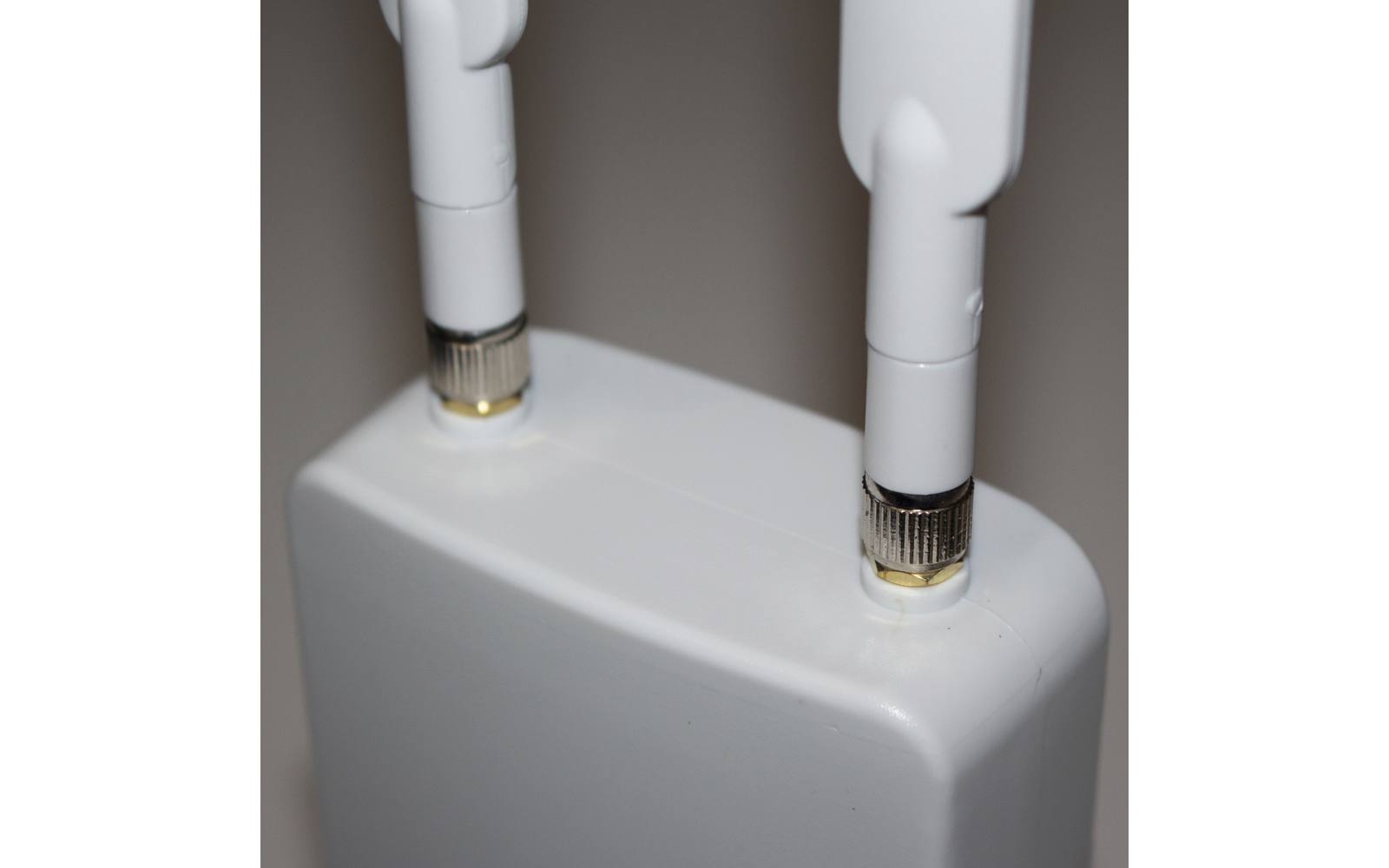 Wit apparaat met twee witte antennes op een grijze achtergrond