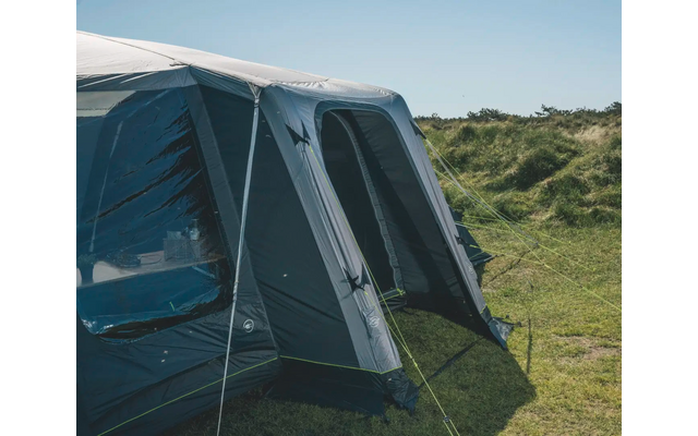 Großes blaues und graues Zelt steht auf einer grünen Wiese bei sonnigem Himmel