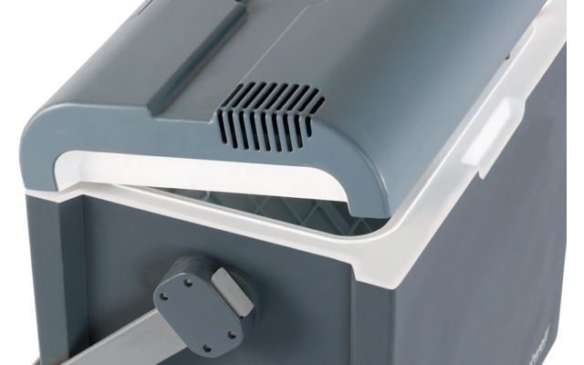 Primo piano di un contenitore in plastica grigio e bianco con coperchio a battente, griglia di ventilazione e una manopola laterale rotonda con braccio attaccato