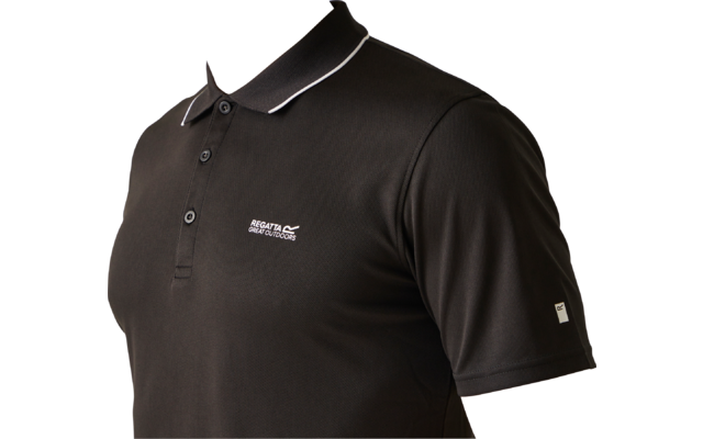 Bovenlichaam van een persoon in een zwart poloshirt met witte rand bij de kraag, drie knopen, wit borstlogo en klein wit label op de mouw; gedeeltelijk gezicht met mond en kin