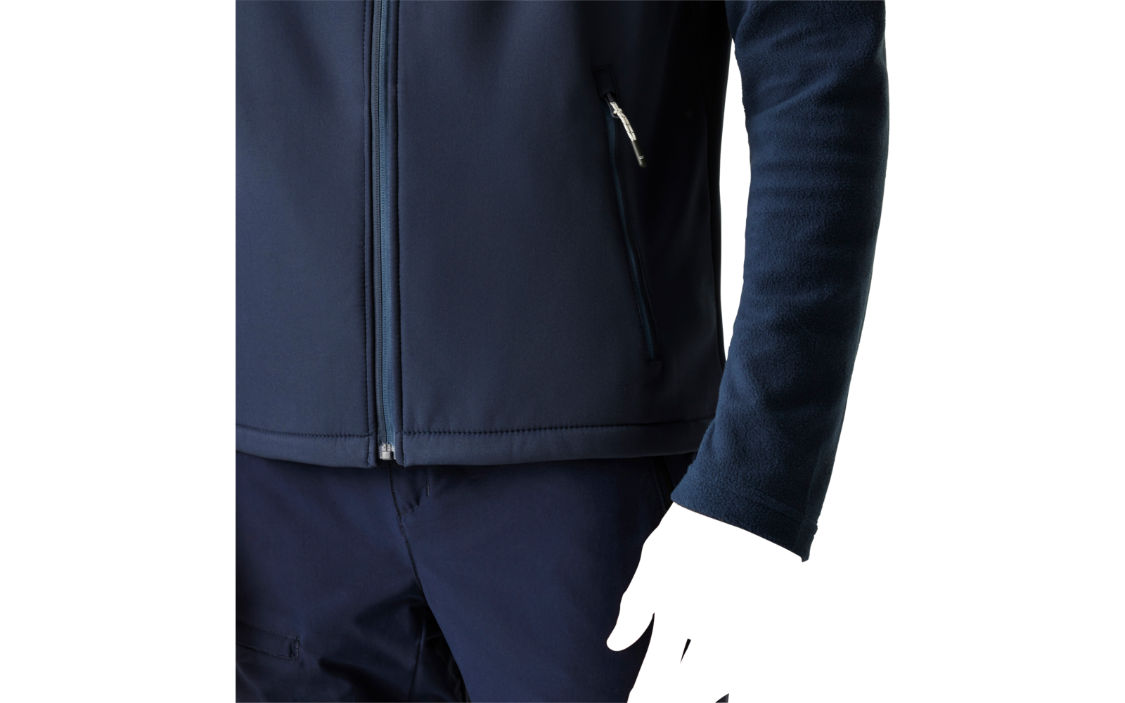 Torso and right arm of a person wearing a dark blue zip-up jacket and dark pants, visible hand, plain light background