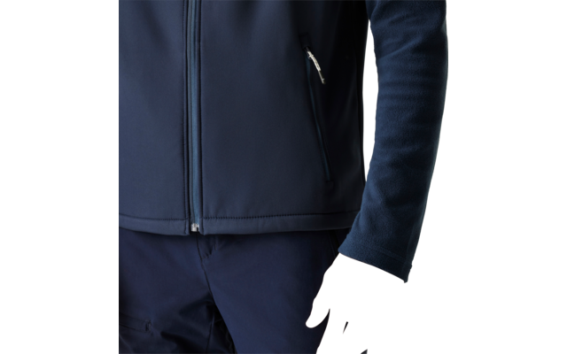 Torso and right arm of a person wearing a dark blue zip-up jacket and dark pants, visible hand, plain light background