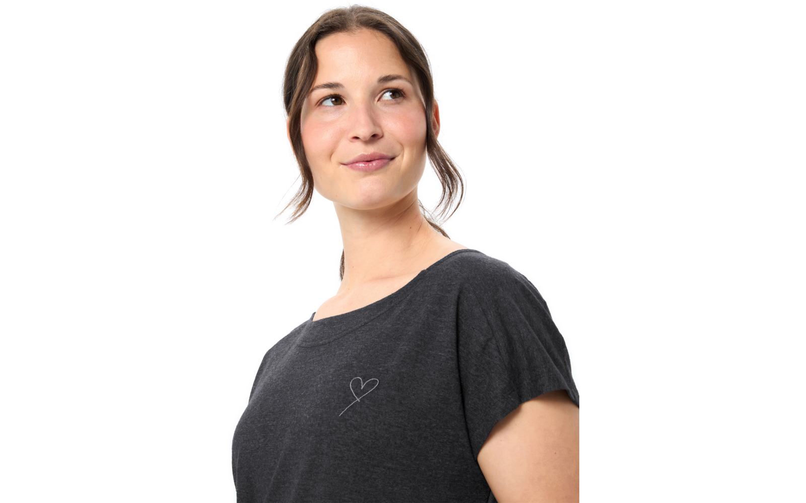Frau im Dreiviertelprofil, schaut nach oben links, braunes Haar zurückgebunden mit losen Strähnen, dunkles T‑Shirt mit kleinem Herz auf der Brust, weißer Hintergrund