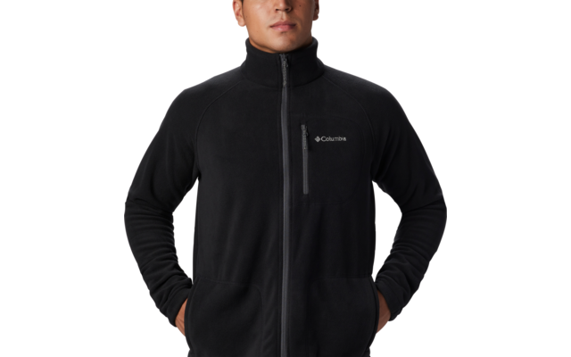 Hombre con chaqueta polar negra con cremallera y manos en los bolsillos
