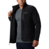 Hombre con suéter negro con cremallera y camiseta gris debajo