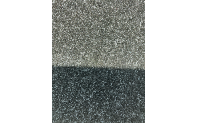 Grob strukturierte Oberfläche, obere Hälfte hellgrau, untere Hälfte dunkelgrau, feine vertikale Linie in der Mitte