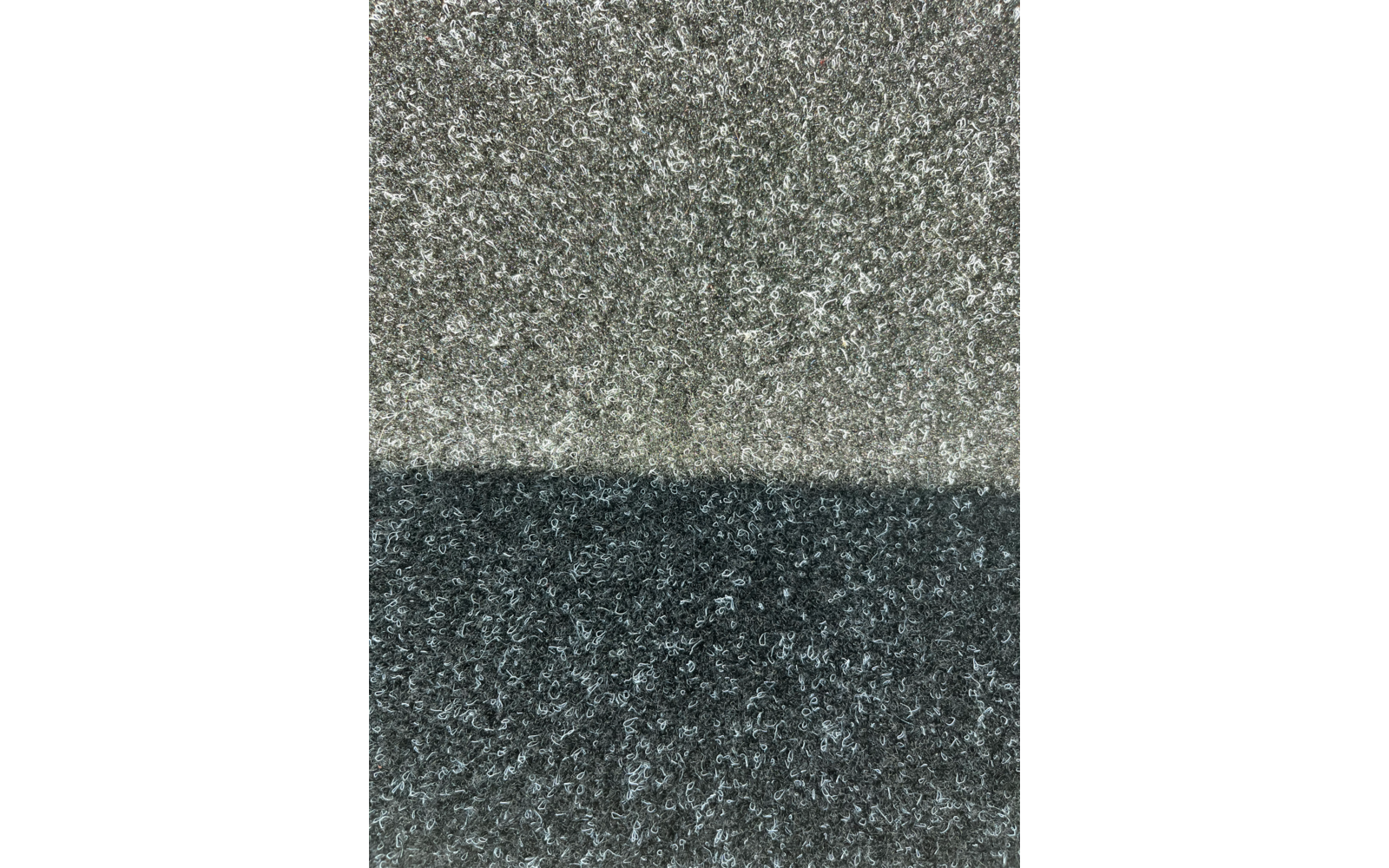 Grob strukturierte Oberfläche, obere Hälfte hellgrau, untere Hälfte dunkelgrau, feine vertikale Linie in der Mitte