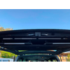 Asiento trasero abierto de un vehículo con vista hacia el exterior, cielo azul de fondo