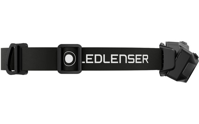 Schwarzes elastisches Stirnband mit weißem Schriftzug "LEDLENSER", mittig ein quadratisches Bedienelement mit rundem Knopf, verstellbare Schnalle links, abgewinkeltes Lampengehäuse rechts