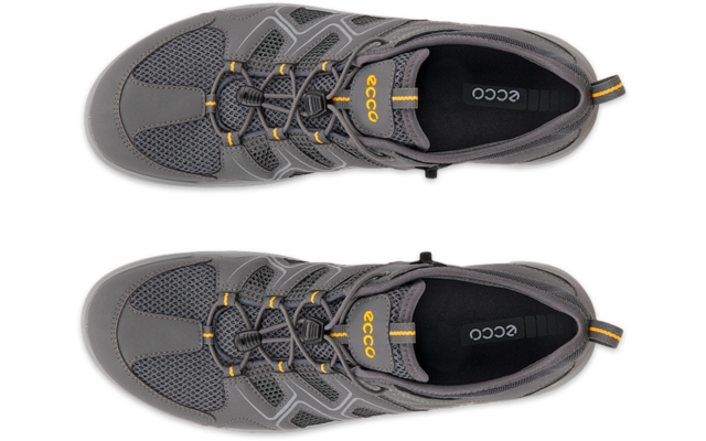 Dos zapatillas grises vistas desde arriba, empeine de malla, cordones tipo cordón con tope, acentos amarillos y plantilla negra con la palabra 'ECCO'