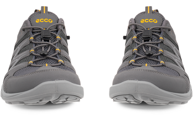 Dos zapatos grises, vista frontal, cordones atados, logotipos amarillos en las lengüetas, empeine de malla y suelas de goma