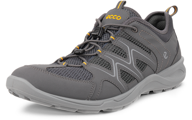 Zapato gris con cordones y paneles de malla, suela gris y detalles naranjas, vista frontal en ángulo