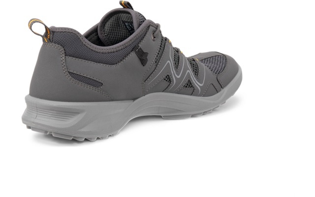 Zapatilla gris vista desde atrás a la derecha, empeine de malla, suela blanca, tirador trasero con detalle amarillo