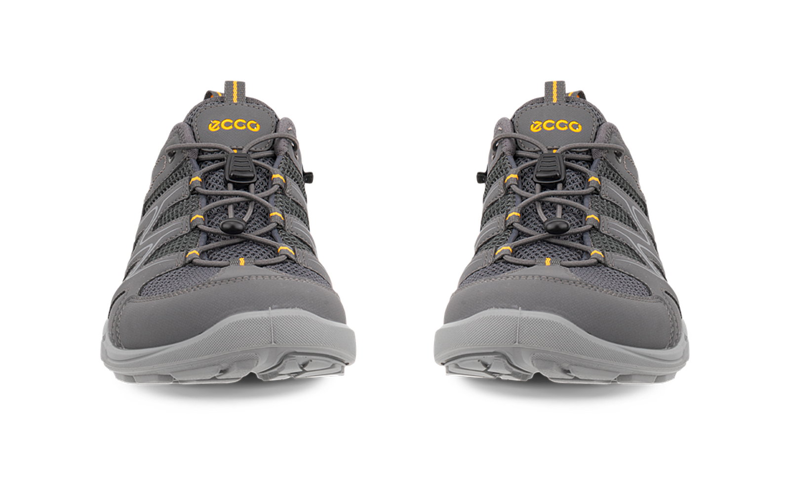 Dos zapatos grises, vista frontal, cordones atados, logotipos amarillos en las lengüetas, empeine de malla y suelas de goma