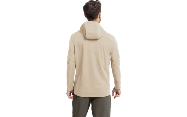 Person von hinten, beige Kapuzenjacke, olivgrüne Hose, kurze dunkle lockige Haare, Hände seitlich sichtbar