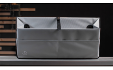 Sac en tissu gris avec compartiments sur une surface sombre