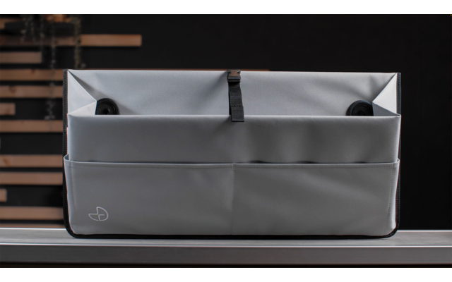 Graue Stofftasche mit Fächern auf einer dunklen Oberfläche