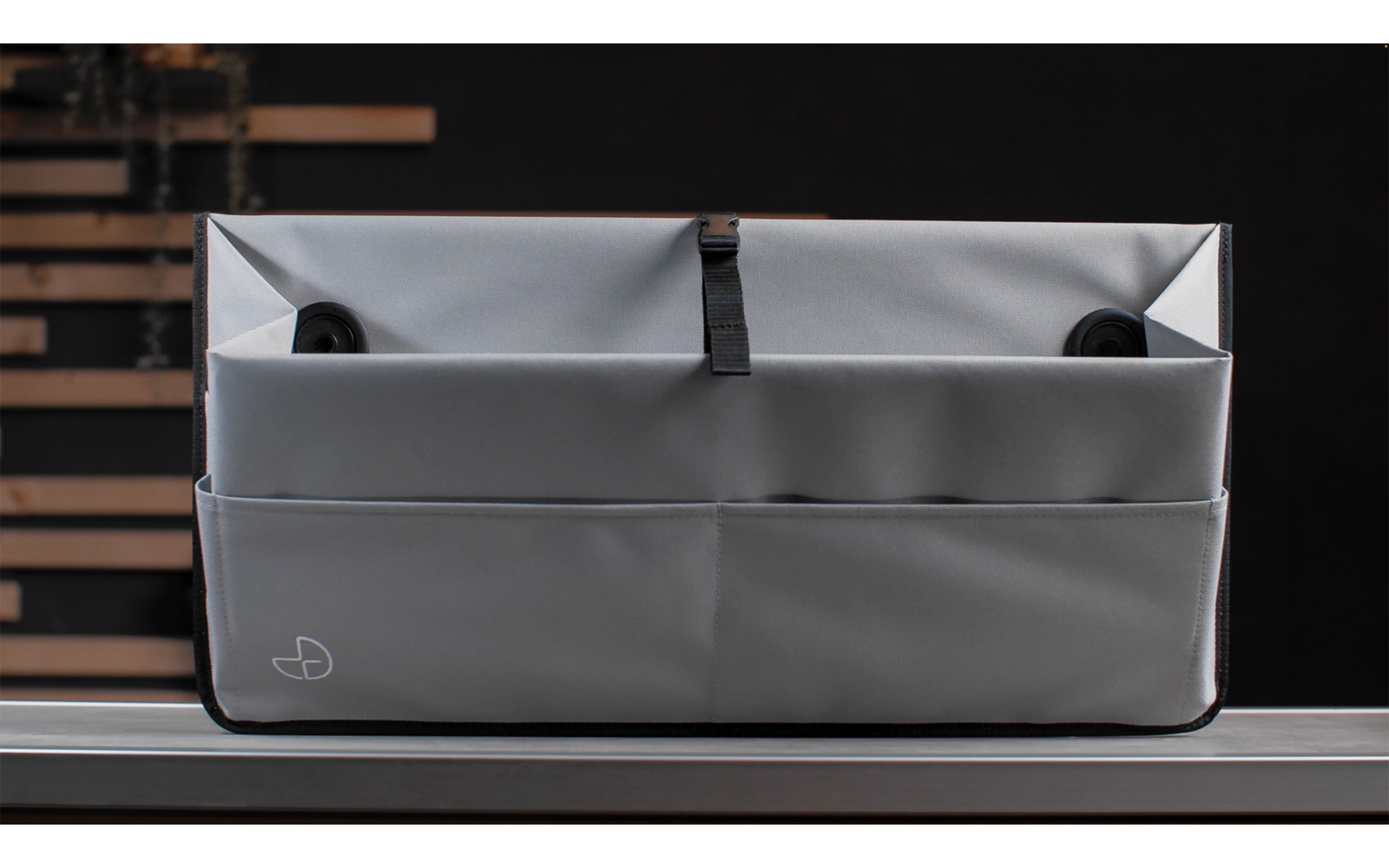 Graue Stofftasche mit Fächern auf einer dunklen Oberfläche