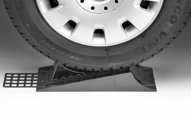 Nahaufnahme eines Fahrzeugs, dessen Vorderrad auf einer Unterlegkeilrolle steht