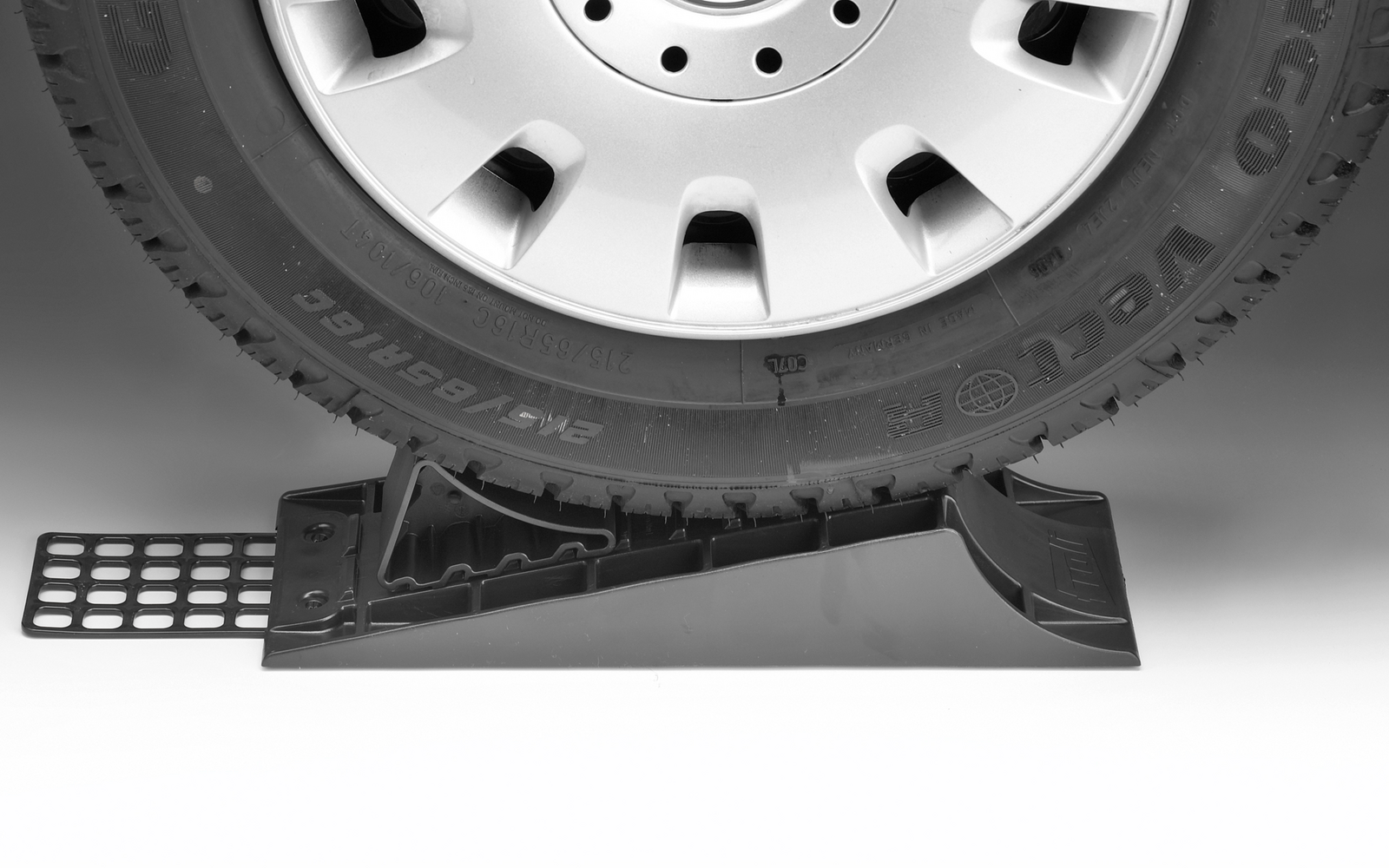 Nahaufnahme eines Fahrzeugs, dessen Vorderrad auf einer Unterlegkeilrolle steht