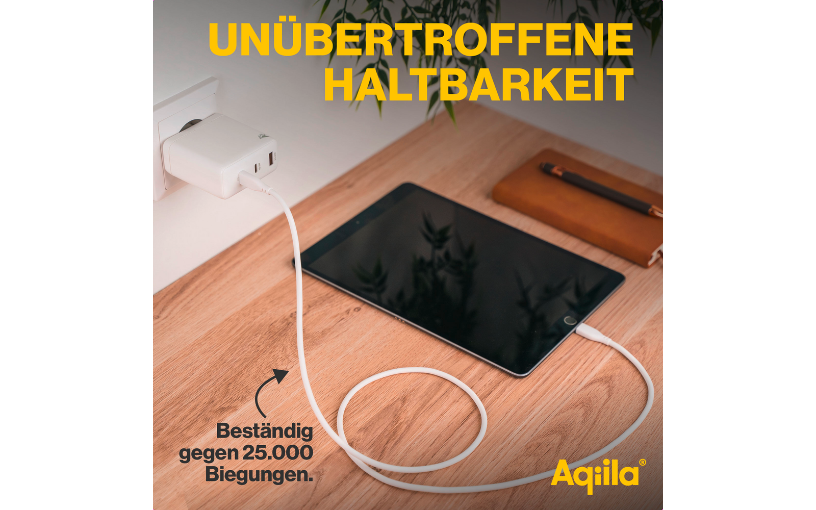 Tablet mit schwarz ausgeschaltetem Display auf weißem Tisch, darunter ein schwarzes Smartphone, darüber eine weiße Steckdose mit Stecker und gelber Text 'UNÜBERTROFFENE HALTBARKEIT'