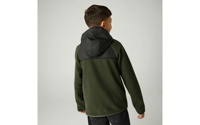 Person von hinten, trägt olivgrüne Fleecejacke mit schwarzer Kapuze und schwarzen Schultereinsätzen, vor hellem neutralem Hintergrund