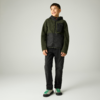 Ein Junge steht vor hellem Hintergrund, trägt eine grün-schwarze Kapuzenjacke, schwarze Hose und weiße Sneaker mit grünen Details, er lächelt