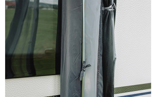 Close-up van grijs textiel met vastgeknoopt koord, een doorzichtige kunststofstrip, een witte gestructureerde wand met een blauwe streep en een donkere ruit met weerspiegeling van een groen veld