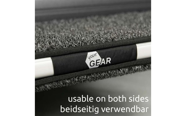 Nahaufnahme einer grauen, strukturierten Matte mit schwarzem Riemen, weißem Sechseck-Logo 'your GEAR' auf dem Riemen und einer weißen Stange; unten der Text 'usable on both sides beidseitig verwendbar'
