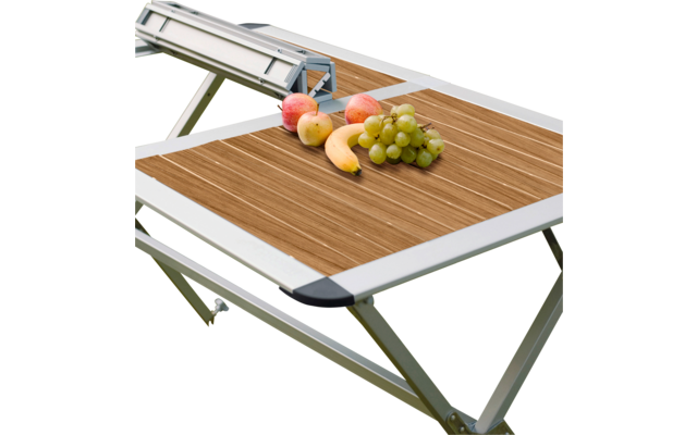 Tragbarer Grill mit Obst auf einem Klapptisch im Freien