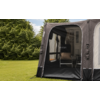 Donkergrijze voortent met open ingang, binnen twee campingstoelen met kussen, groen gras en bomen op de achtergrond