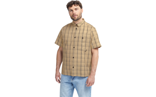 Mann steht, leicht gedreht, trägt beige kariertes Kurzarmhemd und blaue Jeans, Arme locker seitlich