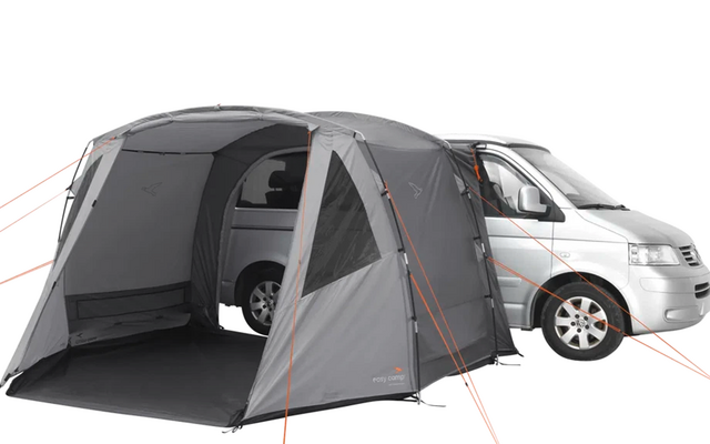 Zelt vor einem weißen Camper mit geöffnetem Eingang und abgespannter Abspannleinen