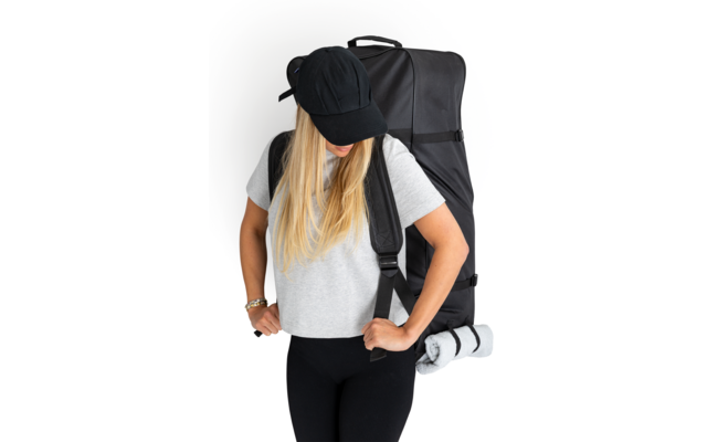 Frau mit langem blonden Haar, schwarzem Hut und schwarzem T-Shirt trägt einen schwarzen Rucksack