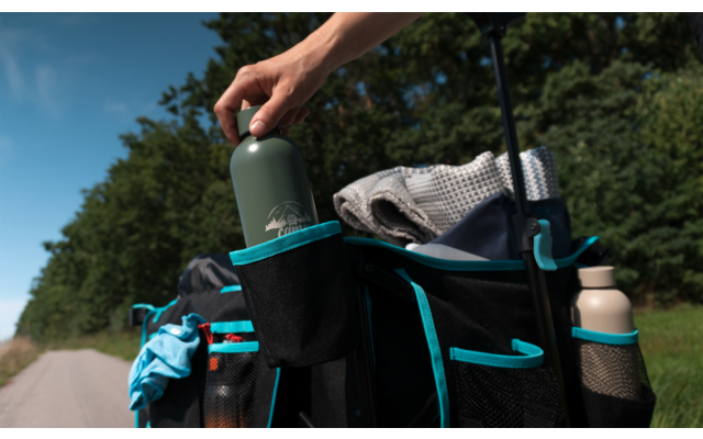 Hand hält Thermobecher über einer Tasche an einem Fahrradlenker