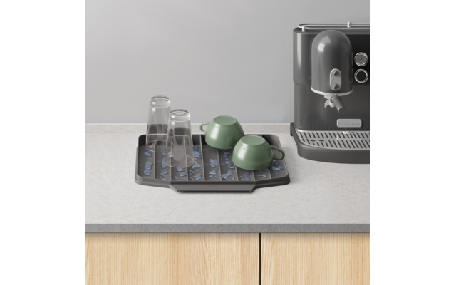 Capsules op tray naast espressomachine op keukenblad