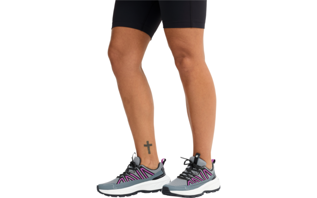 Untere Beine und Füße in grauen Sportschuhen mit lila Akzenten; linker Knöchel mit schwarzem Kreuz-Tattoo