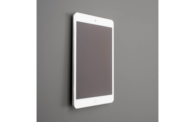 Weißes Tablet mit schwarzem Bildschirm, hochkant an grauer Wand