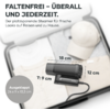Offener Koffer mit gefalteter Kleidung, einer hellen Baseballmütze und einem schwarzen handlichen Gerät mit Bürste; Messlinien mit Beschriftungen '18 cm', '12 cm' und 'T: 9 cm' sowie ein grauer Kreis mit Text 'Ausgeklappt 24 x 9 x 13,3 cm'