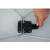 Close-up of a right hand holding a black plastic lever on a black hinge between two silver metal bars against a gray background