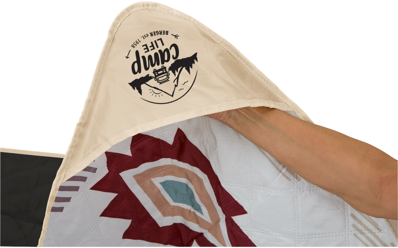 Main tenant une couverture beige avec logo et motif coloré