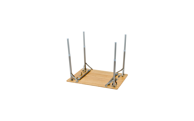 Upside-down rectangular wooden tabletop with four metal folding legs raised on a white background