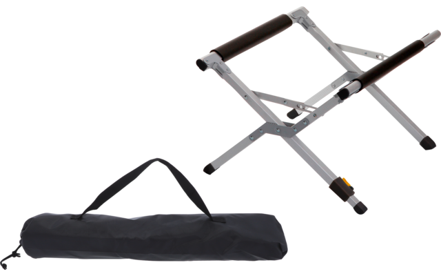 Soporte plegable de metal plateado con almohadillas de goma negras junto a una bolsa de transporte negra