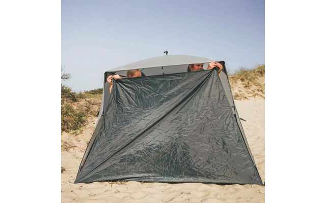 Zwei Personen, die in einem Zelt aus Sand und Strandgras herausblicken