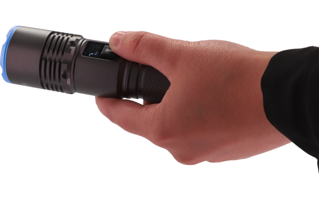 Hand in schwarzem Ärmel hält eine schwarze Taschenlampe mit blauem Ring