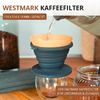 Filtre à café pliable en silicone foncé avec filtre en papier sur un récipient en verre; de l'eau coule d'une bouilloire dans le filtre; bocal de grains de café et table en bois visibles; texte 'WESTMARK KAFFEEFILTER' visible