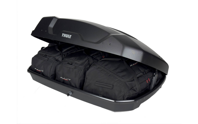 Geöffnete schwarze Thule-Dachbox mit drei schwarzen Reisetaschen, weißer Hintergrund
