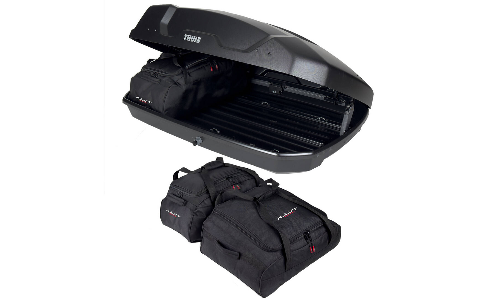 Geöffnete schwarze Dachbox auf weißem Hintergrund, im Inneren eine schwarze Reisetasche, drei weitere schwarze Reisetaschen liegen davor