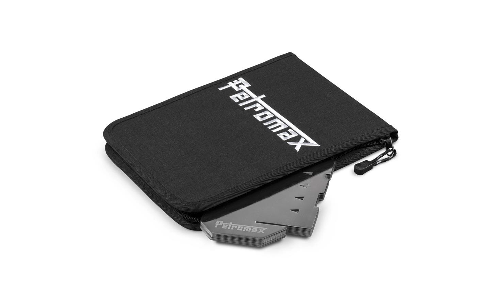 Schwarze Stofftasche mit Reißverschluss und weißem 'Petromax'-Logo; gefaltete metallische, dreieckige Platten ragen teilweise heraus, 'Petromax' eingeprägt