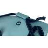 Hellblaue Stofffläche mit dunkelblauen Riemen, weißen Ziernähten und rundem dunkelblauem Logo
